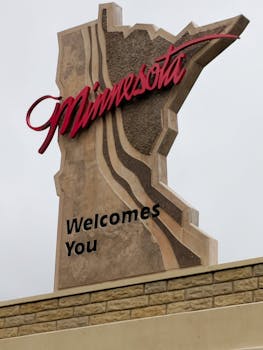 Minnesota welcome sign designates state entrance. Outdoor travel photograph.